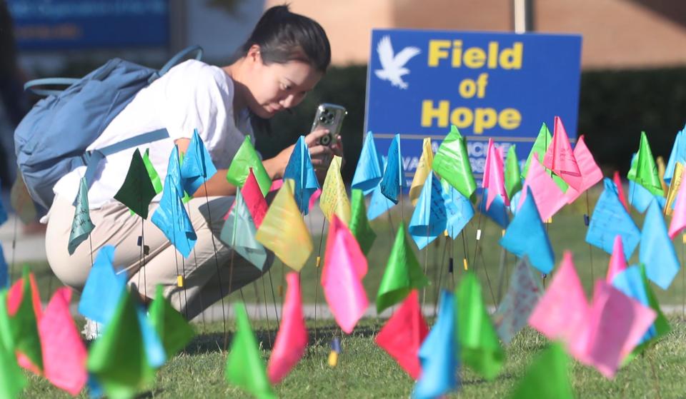 Student Amy Xiong takes a photo of her message among the many messages on small brightly colored flags covering the quad, Tuesday September 12, 2023 as Embry-Riddle Aeronautical University hosts the 10th annual Field of Hope, a suicide awareness event