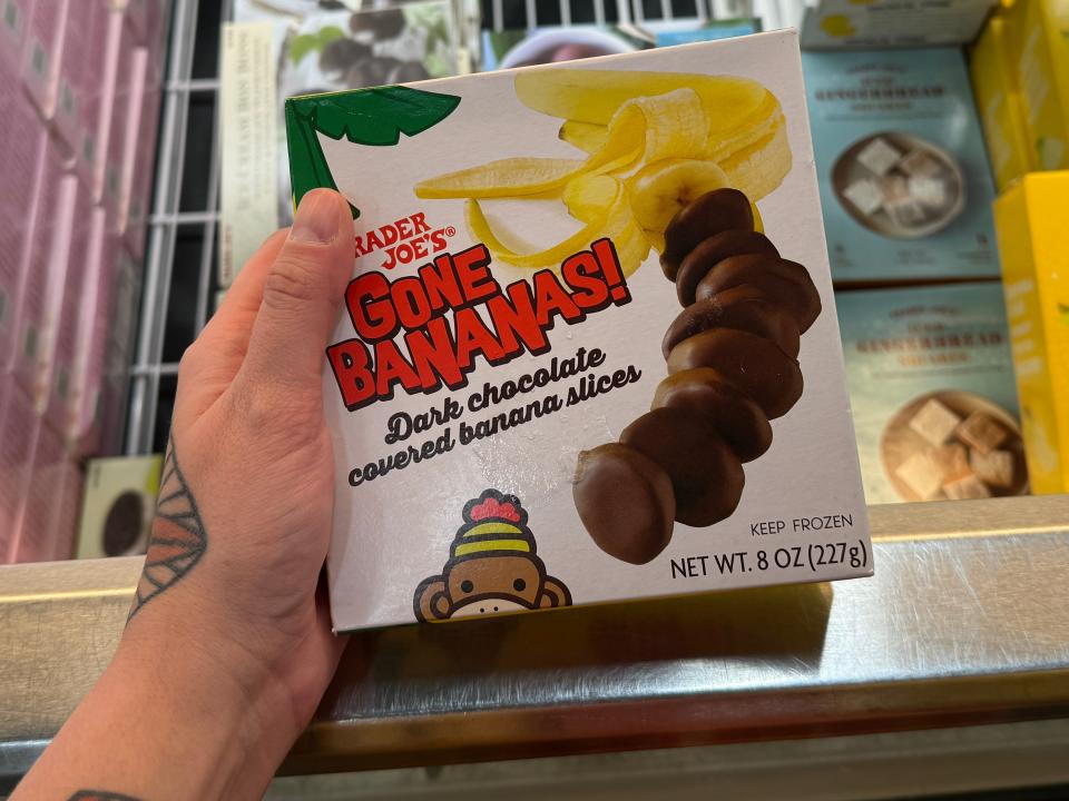 hand holding up a box of frozen chocolate covered bananas at trader joes