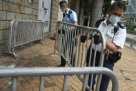 Police set up barriers, Friday, July 30, 2021, as they wait for Tong Ying-kit to arrives at a court in Hong Kong for his sentencing for the violation of a security law for carrying a flag reading "Liberate Hong Kong, Revolution of our times" during a 2020 protest. Tong has been sentenced to nine years in prison in the closely watched first case under Hong Kong’s national security law as Beijing tightens control over the territory. (AP Photo Vincent Yu)