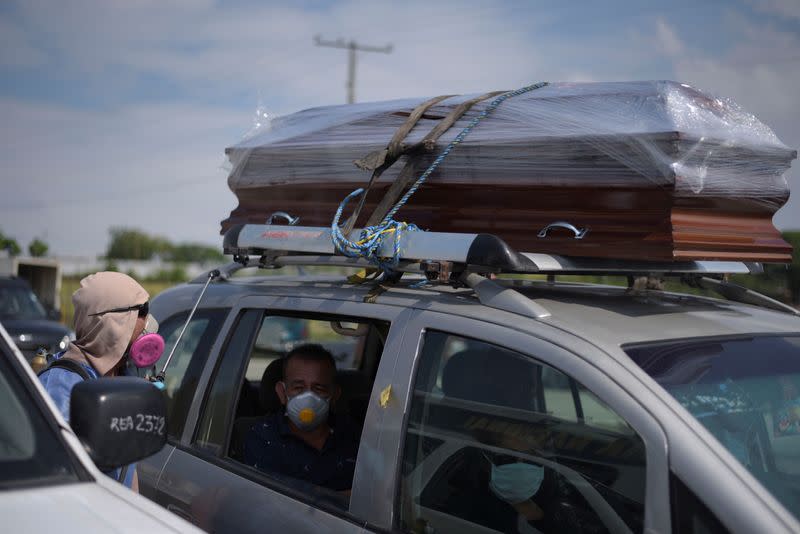 People wait inside a vehicle carrying a coffin lined up to enter a cemetery as Ecuador's government announced on Thursday it was building a "special camp" in Guayaquil for coronavirus disease (COVID-19) victims, in Guayaquil