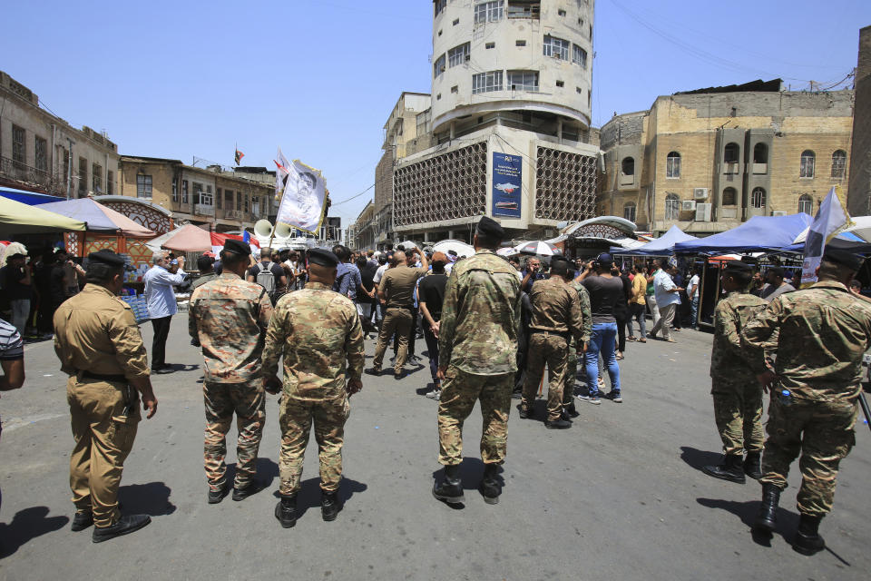 Security forces stand guard during a demonstration in front of the Iraqi central bank as currency plummets against the U.S. dollar, in Baghdad, Iraq, Wednesday, July. 26, 2023. (AP Photo/Hadi Mizban)