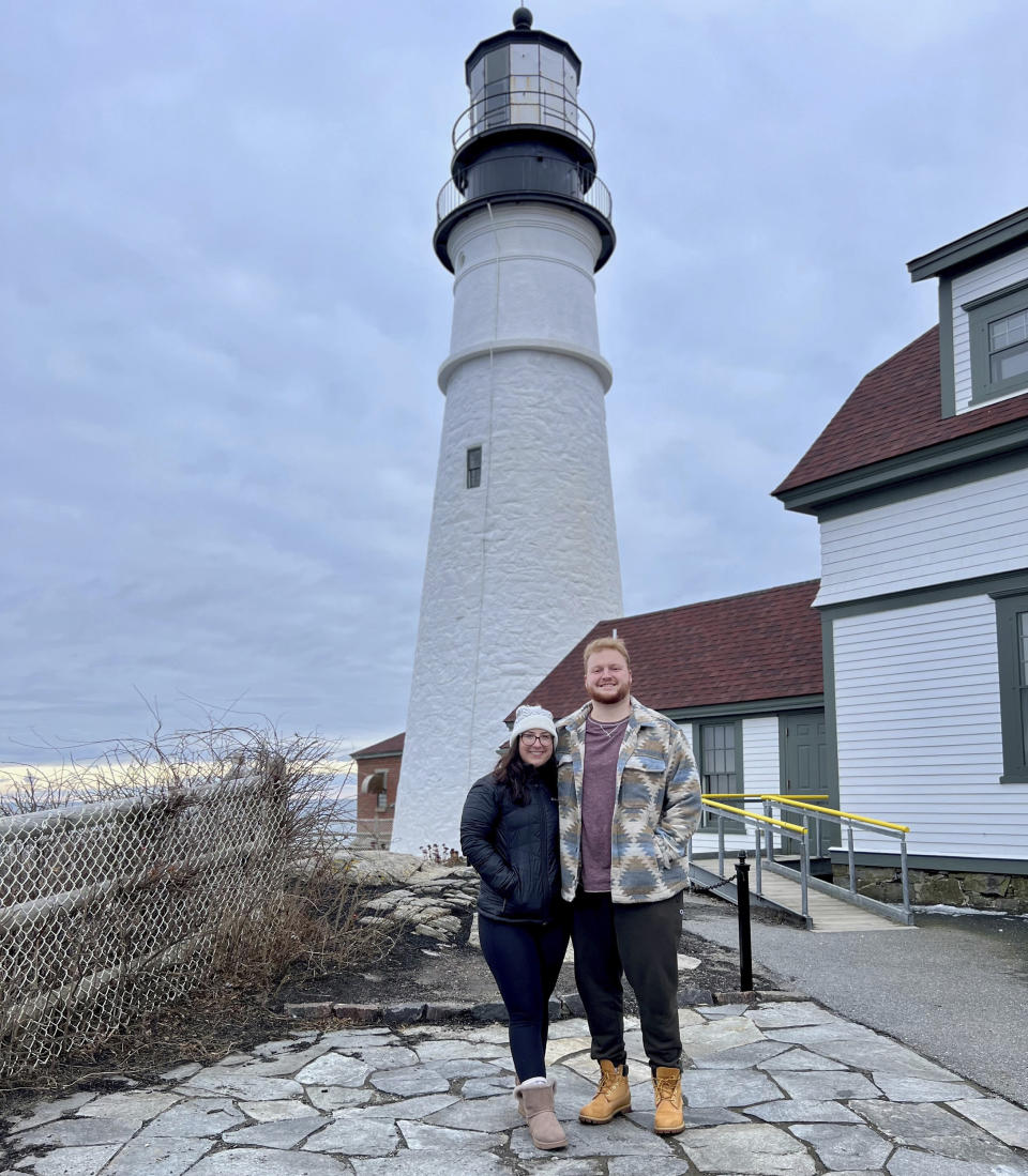 This Feb. 2, 2024 image provided by Shelby Merrill shows Shelby Merrill and Paul Armstrong at the Portland Head Light in Cape Elizabeth, Maine. The two met in college through the Marriage Pact, a popular ritual that students around the country participate in each year. (Shelby Merrill via AP)