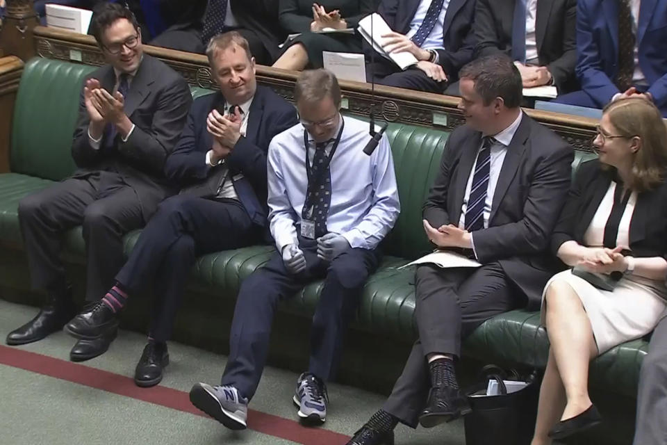 Craig Mackinlay, Conservative MP for South Thanet, is applauded by members of parliament as he returns to the House of Commons for the first time since he was rushed into hospital with sepsis on September 28, which left him with both of his hands and feet amputated, at the Parliament in London, Wednesday May 22, 2024. (House of Commons/UK Parliament via AP)