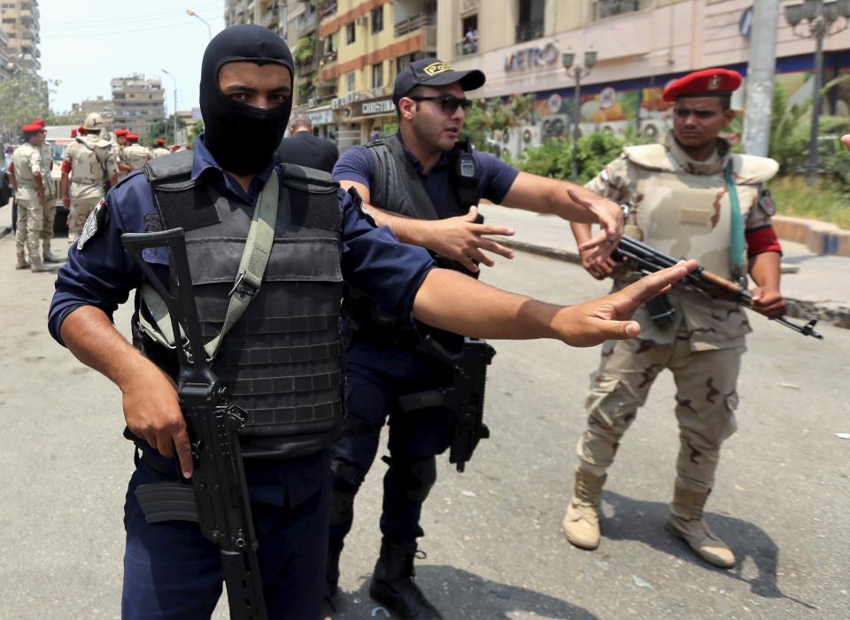 Policemen and army personnel at the site of a car bomb attack on the convoy of Egyptian public prosecutor Hisham Barakat near his house at Heliopolis district in Cairo, Egypt, June 29, 2015. Barakat was injured when a car bomb struck his convoy as it was leaving his home in Cairo on Monday, in a high-profile attack against the judiciary, security and judicial sources said. (REUTERS/Mohamed Abd El Ghany)