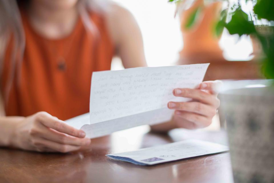 <p>Getty</p> Woman reading a letter.