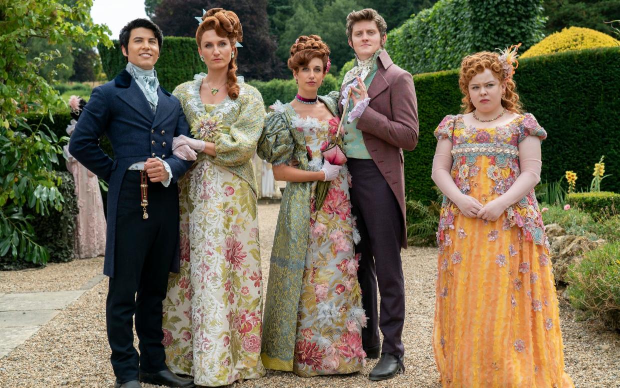 Bridgerton. (L to R) James Phoon as Harry Dankworth, Bessie Carter as Prudence Featherington, Harriet Cains as Philipa Featherington, Lorn Macdonald as Albion Finch, Nicola Coughlan as Penelope Featherington