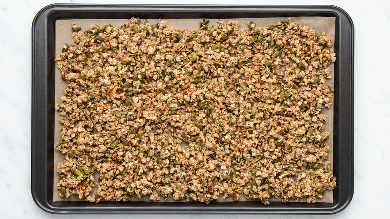 Granola spread out on baking sheet