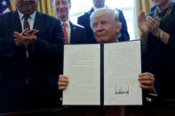 U.S. President Donald Trump is surrounded by business leaders as he signs an executive order on regulatory reform at his desk in the Oval Office at the White House, U.S. February 24, 2017. REUTERS/Jonathan Ernst