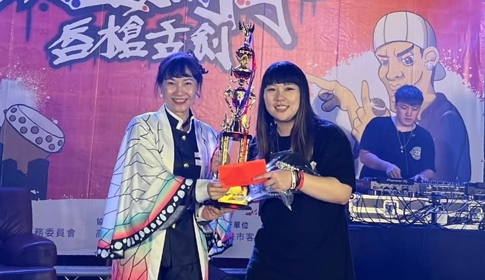 楊瑞霞(左)將冠軍盃及獎金頒給YOYO。   圖:高雄市客委會/提供