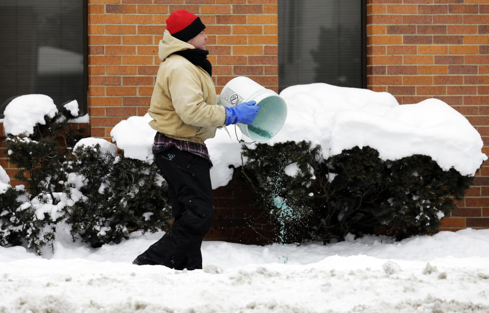 A man spreads salt on icy sidewalk in Chicago, Friday, Jan. 3, 2014. The snowstorm may finally have left town but a winter weather advisory is in effect for this evening when southerly winds are expected to kick up blizzard-like conditions. (AP Photo/Nam Y. Huh)