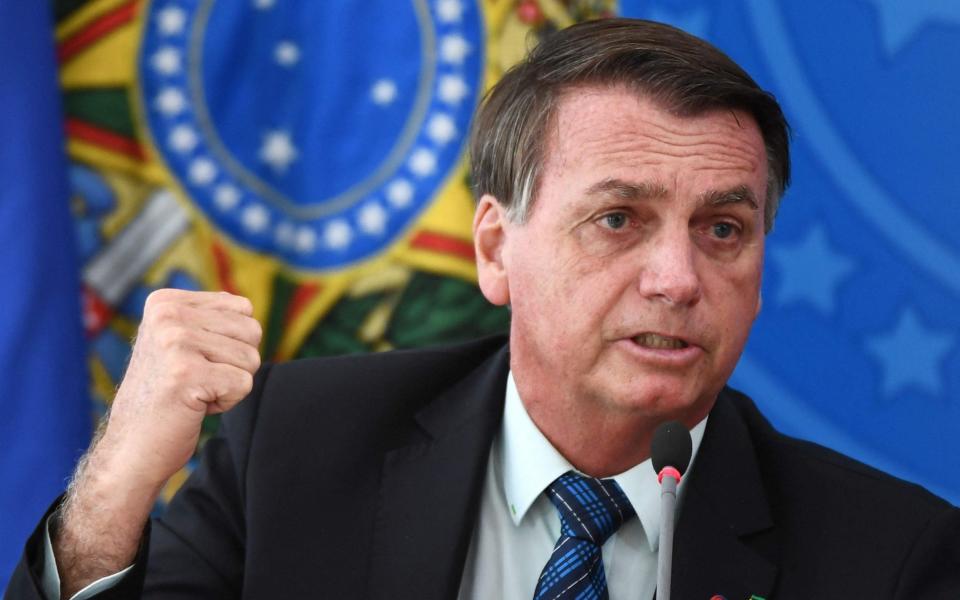 Brazilian President Jair Bolsonaro gestures as he speaks during a press conference - Evarsito Sa/AFP