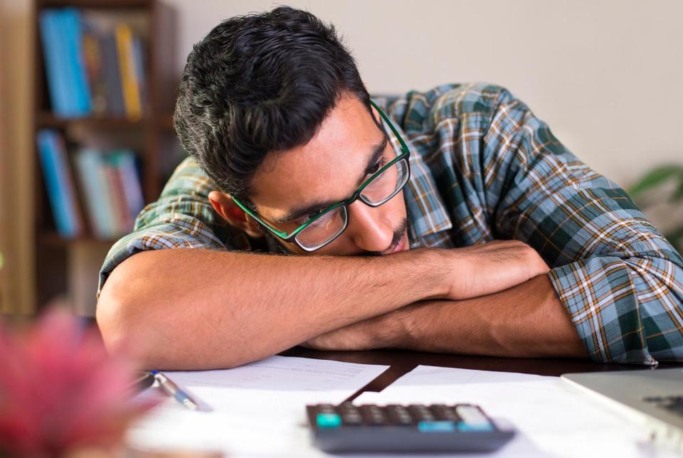 PHOTO: a depressed Indian man sits resting his head in his arms. (STOCK PHOTO/Getty Images)