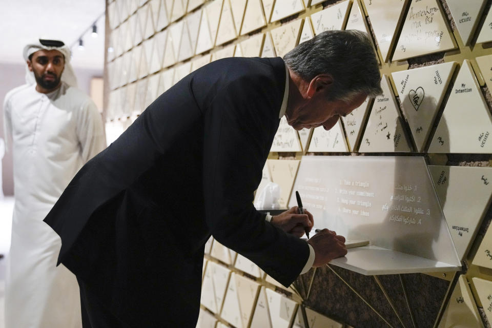 U.S. Secretary of State Antony Blinken writes on a tile at the Abrahamic Family House, in Abu Dhabi, United Arab Emirates, Saturday Oct. 14, 2023. Blinken wrote "Light in the darkness" on the tile and placed the tile on the intention wall. (AP Photo/Jacquelyn Martin, Pool)