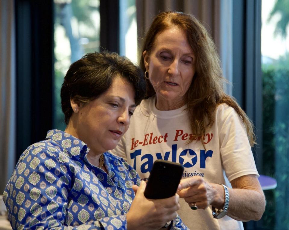 Penny Taylor looks at election results with Elena Mola on Tuesday night, Aug. 23, 2022, in Naples.