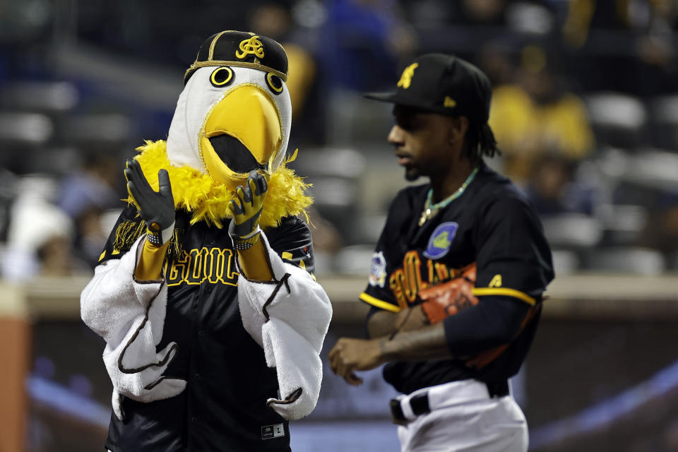 Águilas Cibaeñas' mascot cheers as Ronnie Williams walks to the dugout during the fourth inning against Los Tigres del Licey in a Dominican Winter League baseball game Friday, Nov. 10, 2023, in New York. (AP Photo/Adam Hunger)