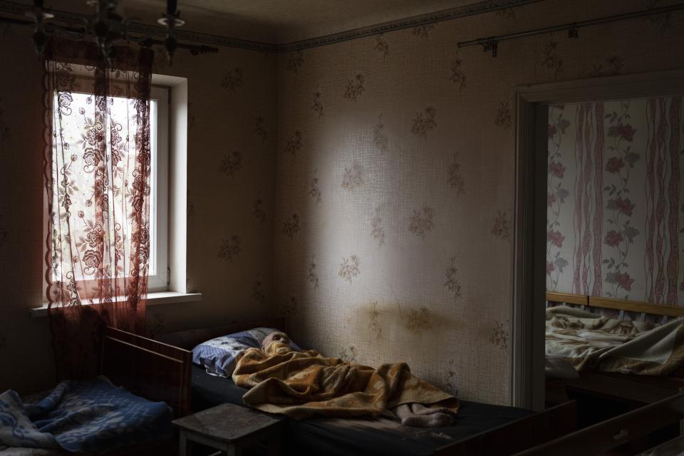 An elderly man lies at a hospice center in Chasiv Yar in the Donetsk district of Ukraine, Monday, April 18, 2022. The image was part of a series of images by Associated Press photographers that was a finalist for the 2023 Pulitzer Prize for Feature Photography. (AP Photo/Petros Giannakouris)
