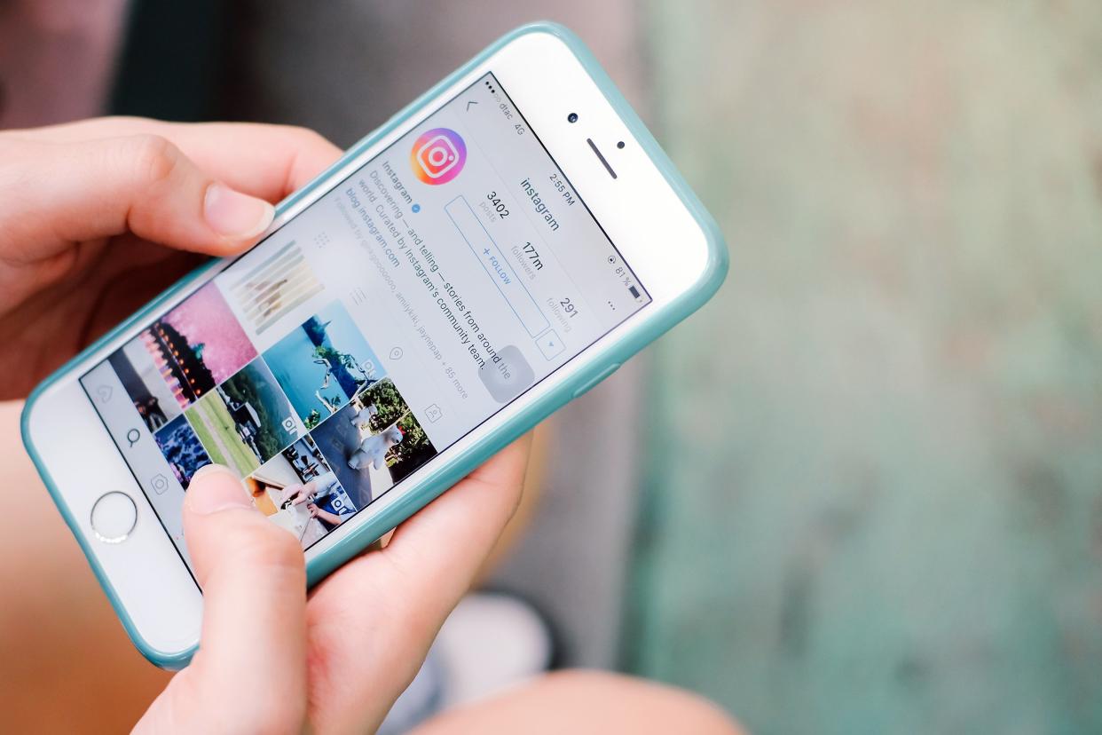 Closeup of hand looking at Instagram on a smartphone