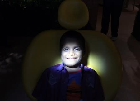 A 7-year-old boy, whose tooth-like structures were removed from his mouth, sits inside a hospital in Chennai