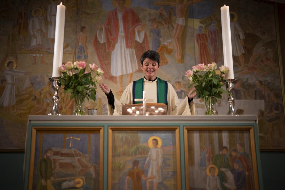 The Rev. Siv Limstrand celebrates evening service with congregants at Svalbard Kirke in Longyearbyen, Norway, Tuesday, Jan. 10, 2023. For the lone pastor in this fragile, starkly beautiful environment, the challenge is to fulfill the church's historical mission of ministering to those in crisis while addressing a pressing and divisive contemporary challenge. "We pray every Sunday for everyone who's affected by climate change," Limstrand said. (AP Photo/Daniel Cole)