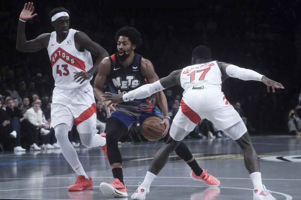 Brooklyn Nets' guard Spencer Dinwiddie, center, drives between Toronto Raptors' Pascal Siakam (43) and Dennis Schroder (17) during the first half of an NBA In-Season Tournament basketball game Tuesday, Nov. 28, 2023, in New York. (AP Photo/Bebeto Matthews)