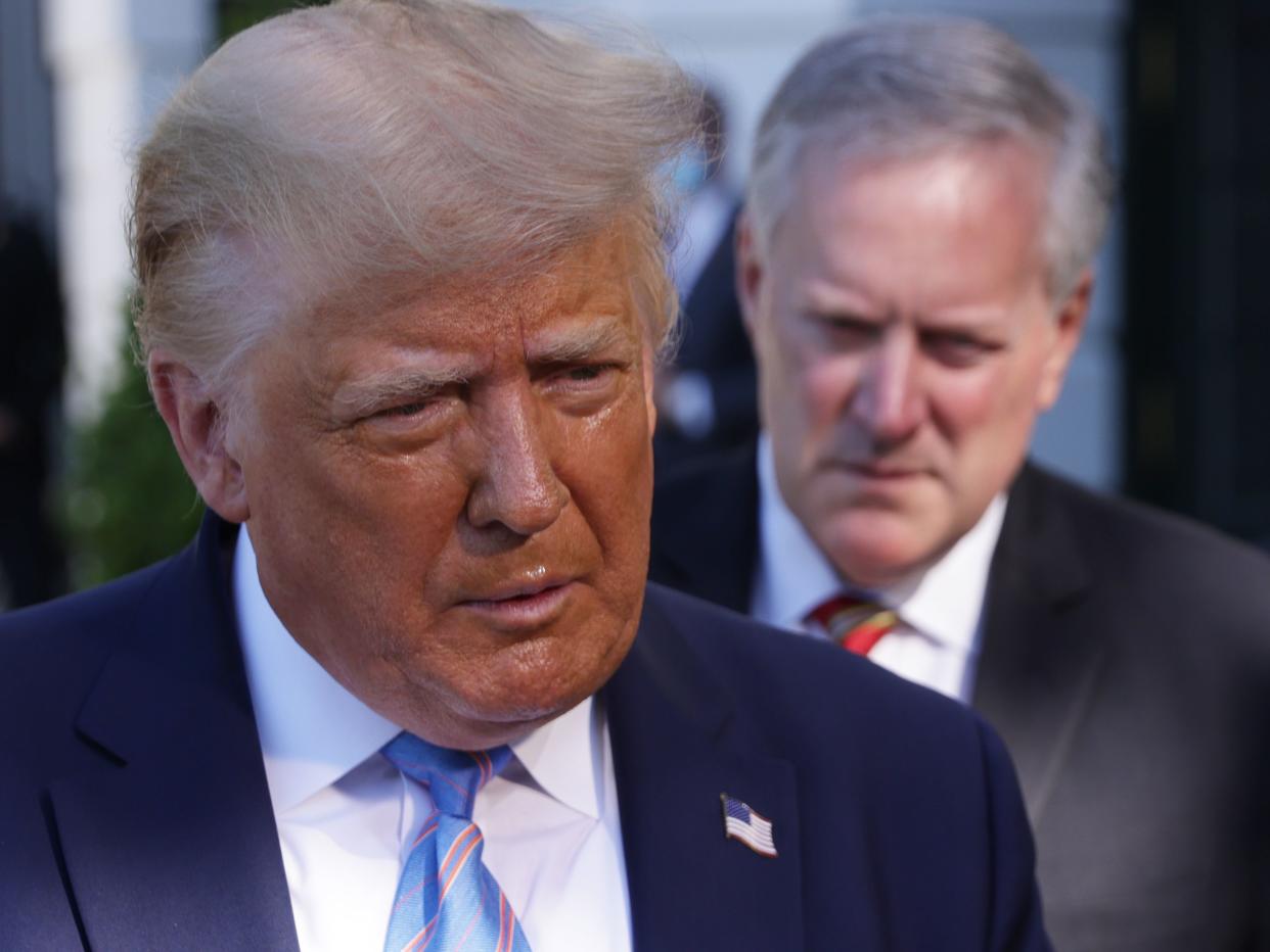 Then-President Donald Trump speaks as then-White House Chief of Staff Mark Meadows listens.