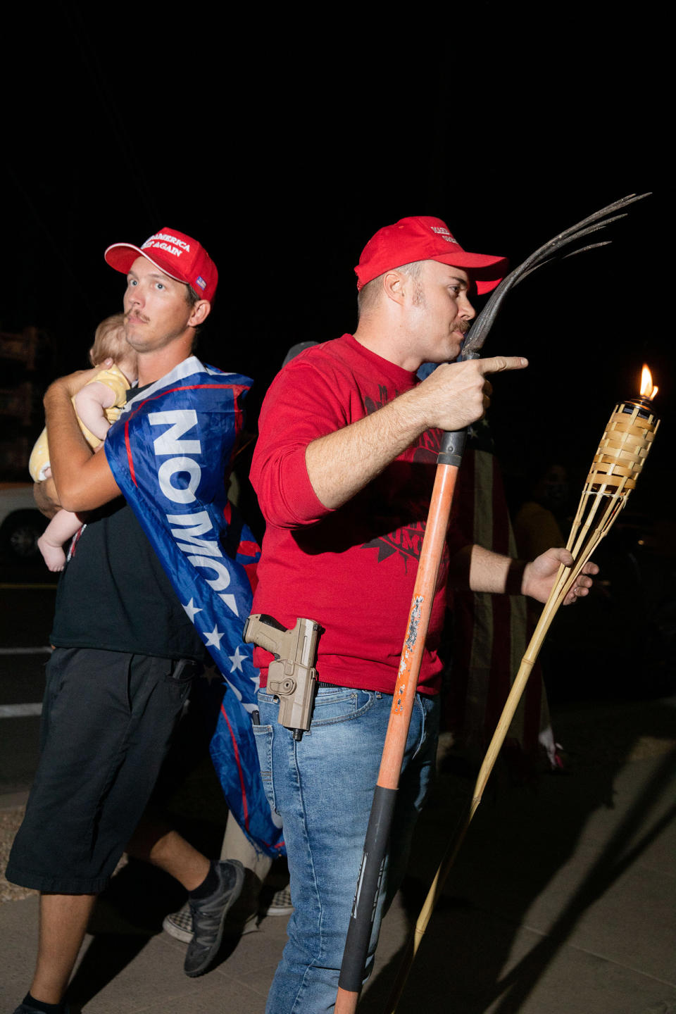 A father holding a child walks by a man with a pitchfork, gun and Tiki torch at the Maricopa County election office in Phoenix on Nov. 5, <a href="https://time.com/5909201/2020-election-photographs/" rel="nofollow noopener" target="_blank" data-ylk="slk:two days;elm:context_link;itc:0;sec:content-canvas" class="link ">two days</a> after the election.<span class="copyright">Sinna Nasseri for TIME</span>