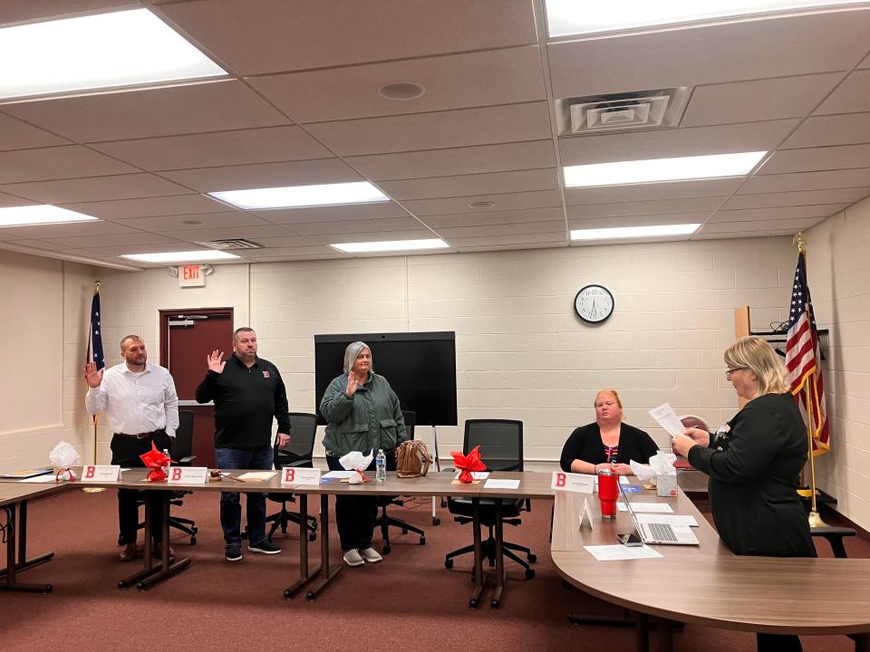 Chad Redmon, left, Randy Blanenship and Christa Graves were sworn into office by Bucyrus City School District Treasurer Lisa Thoman-Cha.