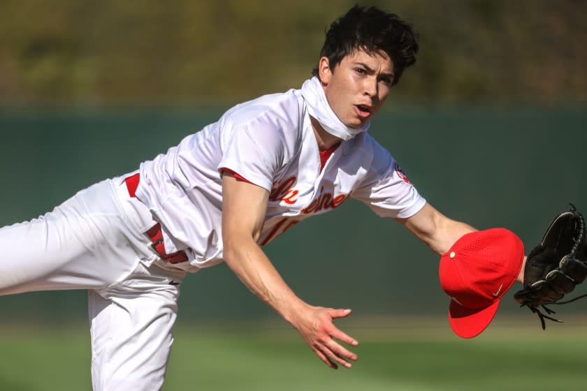 Encino, CA, Tuesday, March 23, 2021 - A hard wind blows the cap off Harvard Westlake pitcher Christian Becerra as he delivers a pitch early in the game against JSerra Catholic at O'Malley Family Field. (Robert Gauthier/Los Angeles Times)