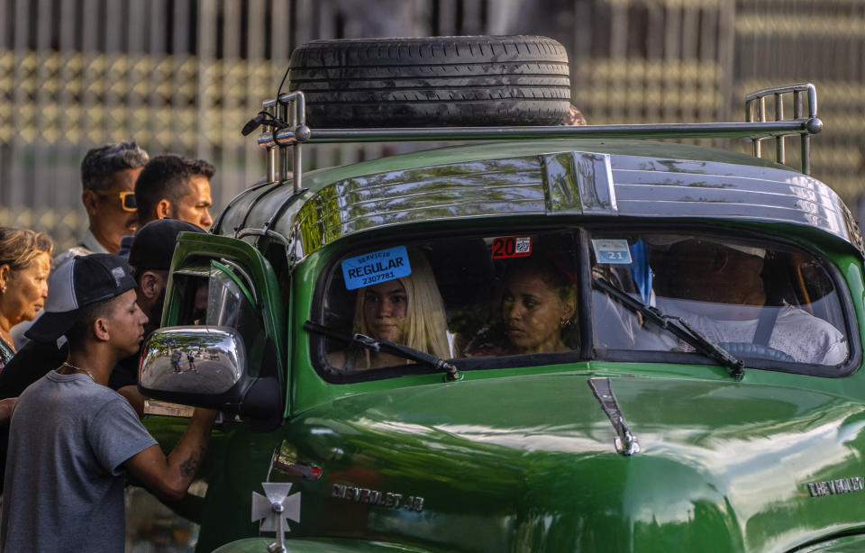 La gente intenta subirse a un taxi colectivo en La Habana, Cuba, el jueves 6 de abril de 2023. (AP Foto/Ramón Espinosa)