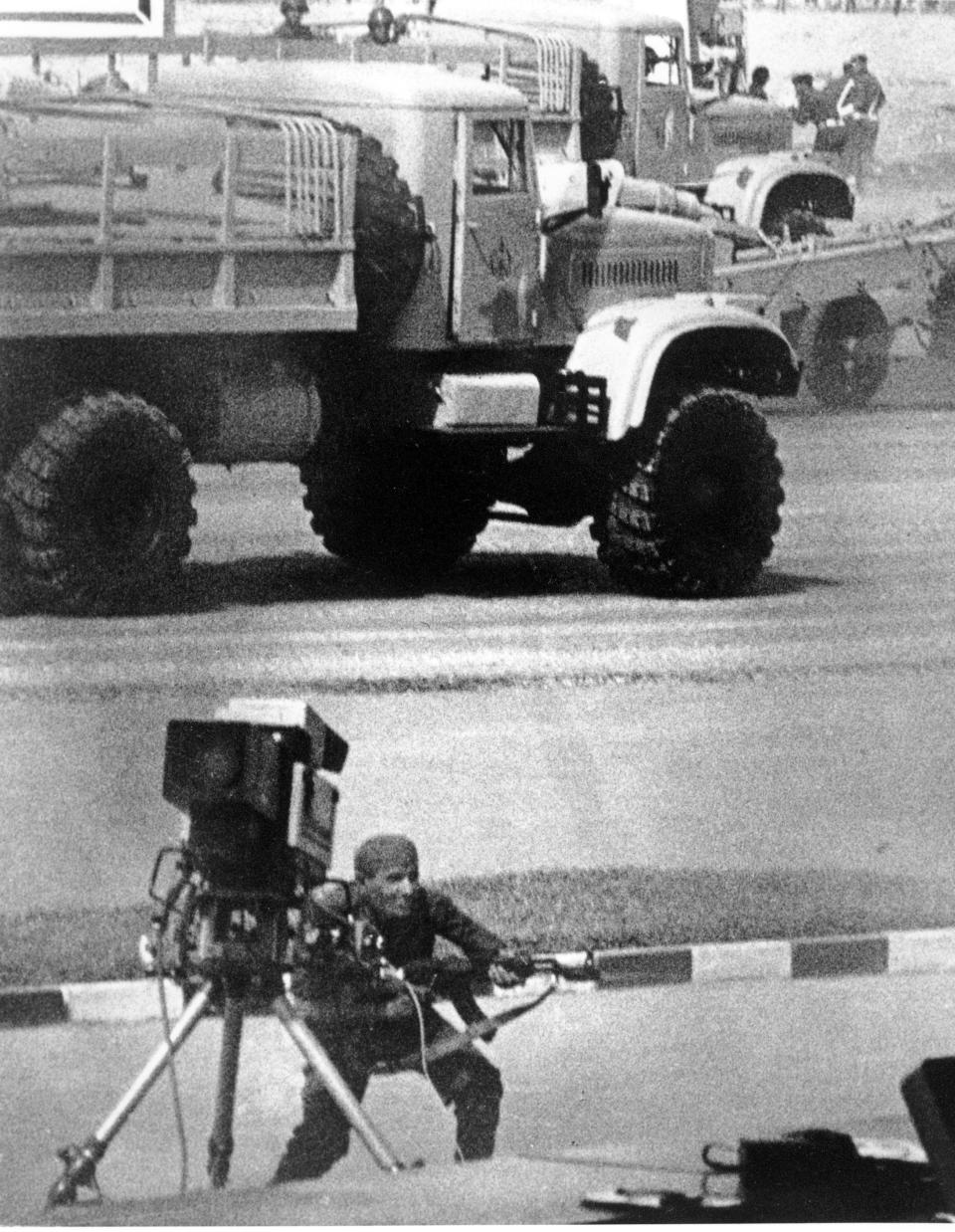 FILE - In this Oct. 6, 1981 file photo, a gunman, wearing an Egyptian army uniform, fires an automatic Kalashnikov rifle into the reviewing stand during an attack that took the life of President Anwar Sadat and five others in Cairo, Egypt. Iran's 1979 Islamic Revolution initially inspired both Islamic militants and Islamists across the Mideast. They saw the revolution as the starting gun in a competition to push out the strongman Arab nationalism that had taken hold across the Middle East. However, analysts say Iran's push to back militants in the wider Mideast and Saudi Arabia's efforts to mobilize the Sunni world against the Shiite power would turn many away. (AP Photo, File)