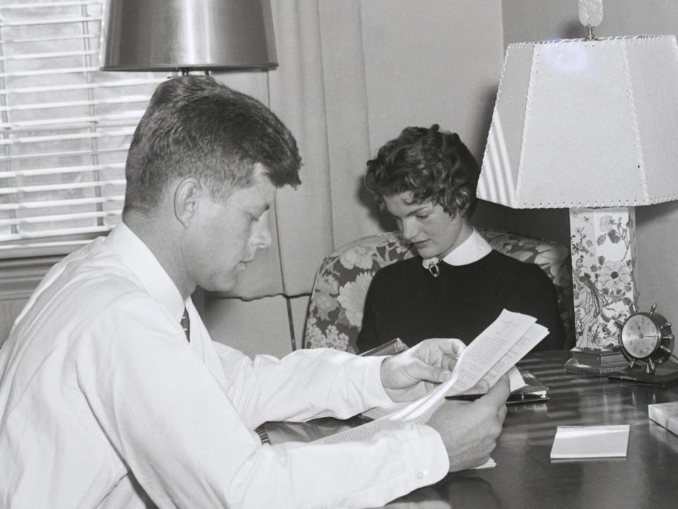 Senator John F. Kennedy and his wife, the former Jacqueline Bouvier get down to an evening of studying after dinner.