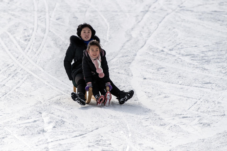 A North Korean woman and child ride a sled on a lower slope at Masikryong Ski Resort on Feb. 5, near Wonsan, North Korea.