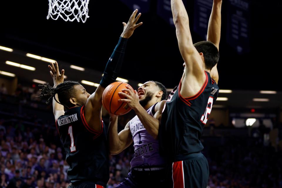 Kansas State guard Markquis Nowell (1) is fouled while attempting to score as Texas Tech's Lamar Washington (1) and Daniel Batcho (12) defend during the second half of an NCAA college basketball game, Saturday, Jan. 21, 2023, in Manhattan, Kan. (AP Photo/Colin E. Braley)