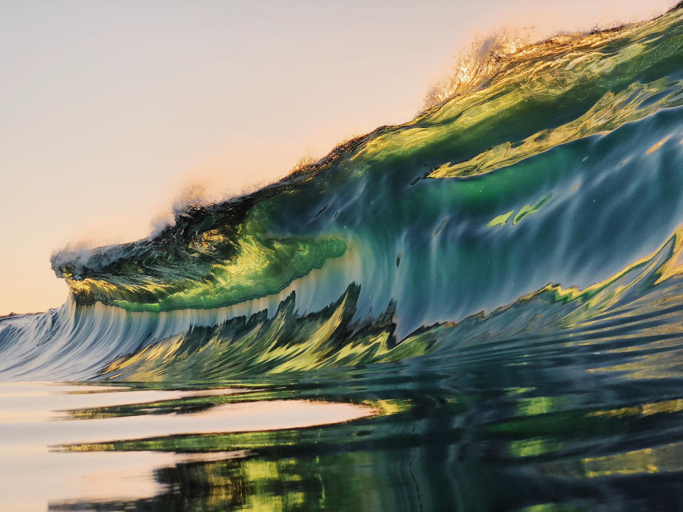 <p>“I am obsessed with photographing waves when there is interesting light, such as on sunrise or sunset — I love the light that leaks through the waves.” (Photo: Ryan Pernofski/Caters News) </p>