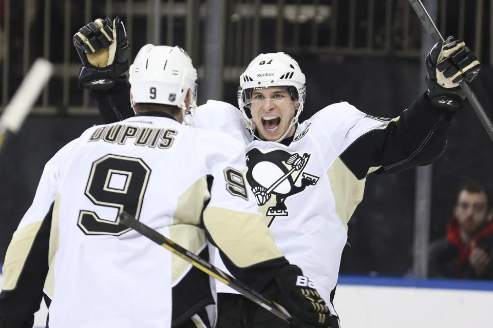 FILE - In this Dec. 18, 2013 file photo, Pittsburgh Penguins center Sidney Crosby (87) reacts after right wing Pascal Dupuis (9) scored during the third period of an NHL hockey game against the New York Rangers in New York. Crosby was named to Canada's men's national hockey team for the Sochi Olympics on Tuesday, Jan. 7, 2014. (AP Photo/John Minchillo, File)