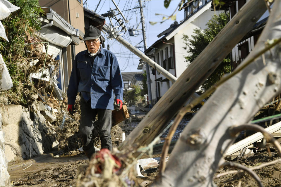 A man walks through debris in the aftermath of Typhoon Hagibis, in Nagano, central Japan Wednesday, Oct. 16, 2019. The typhoon hit Japan's main island on Saturday with strong winds and historic rainfall that caused more than 200 rivers to overflow, leaving thousands of homes flooded, damaged or without power. (Iori Sagisawa/Kyodo News via AP)