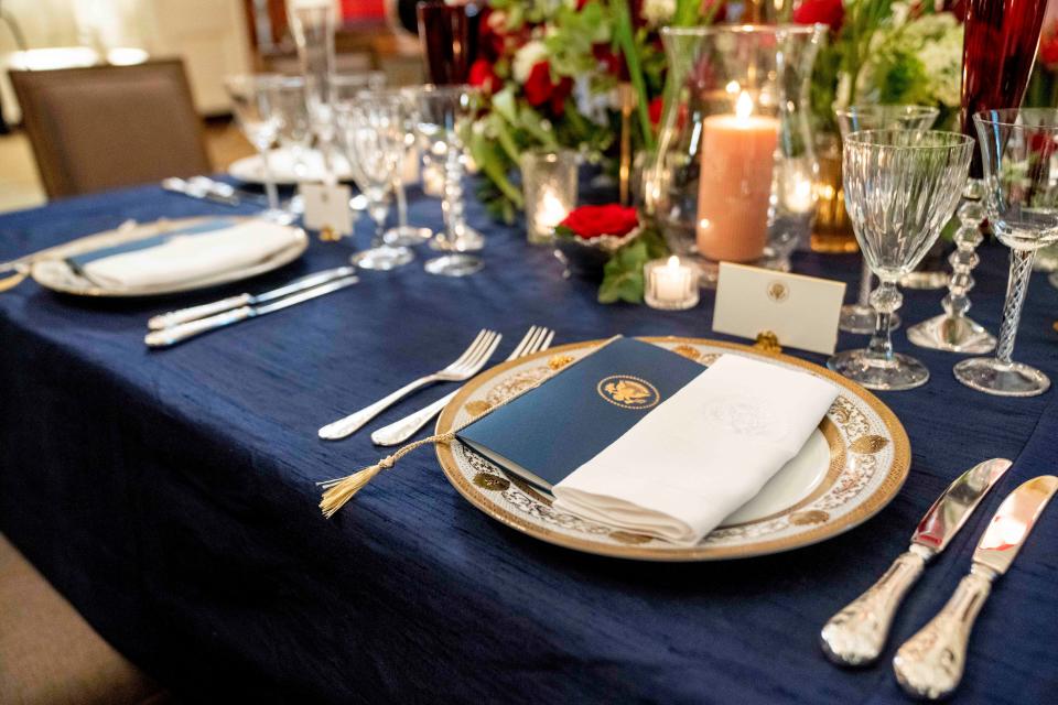 A table setting on display during a media preview for the state dinner for France, in the State Dining Room of the White House Nov. 30, 2022.