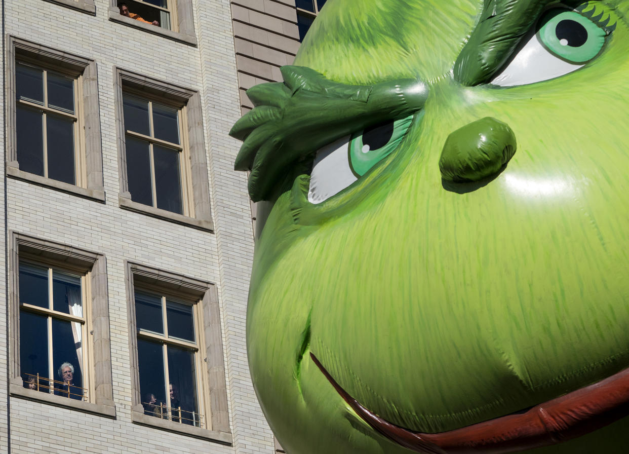 The Grinch balloon passes by windows of a building on Central Park West during Macy's Thanksgiving Day Parade in New York Thursday, Nov. 23, 2017. (AP Photo/Craig Ruttle)
