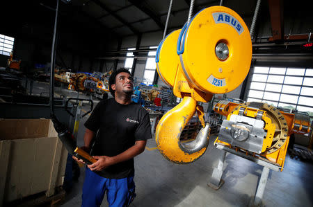 Merhawi Tesfay, an immigrant from Eritrea poses during a Reuters interview at German plant engineering firm Kremer Machine Systems where he found a job as electrician and plant manufacturer in Gescher near Muenster, Germany, August 4, 2017. Picture taken August 4, 2017. REUTERS/Wolfgang Rattay