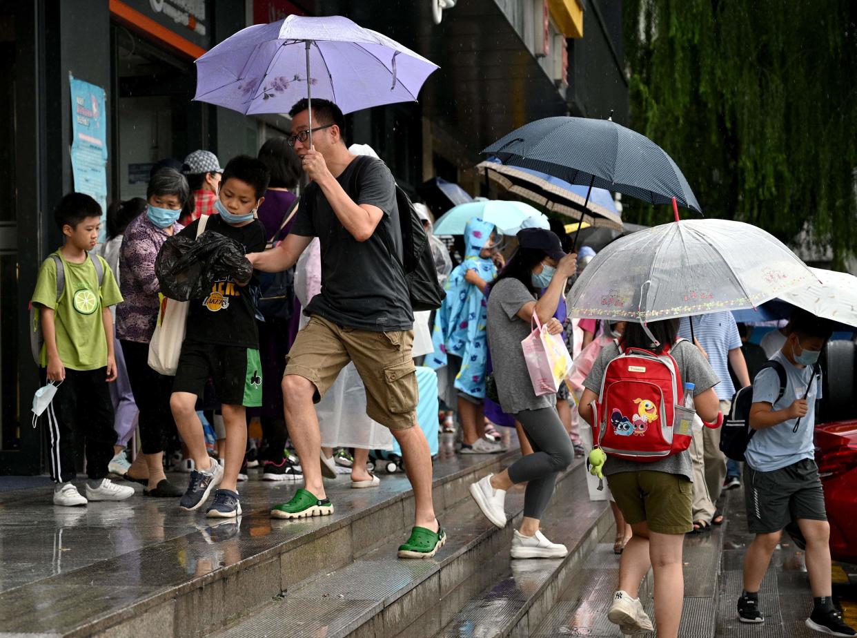 This picture taken on July 29, 2021, shows students and parents walking after attending a private after-school education in Haidan district of Beijing.