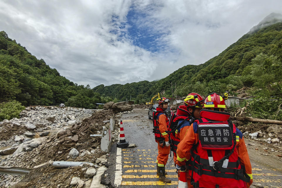 In this photo released by Xinhua News Agency, rescue workers gather at the aftermath of a mudslide in Weiziping village of Luanzhen township on the outskirts of Chang'an district, Xi'an of northwestern China's Shaanxi Province on Saturday Aug. 12, 2023. The mudslide caused by torrential rains killed at least two people on the outskirts of Xi'an in western China, an official news agency said Saturday, while some trains in the northeast were canceled as a powerful storm lashed the region. (Zhang BinXinhua via AP)