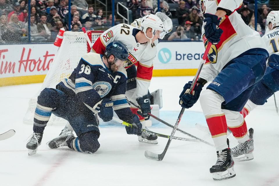 Columbus Blue Jackets center Boone Jenner (38) tries to pass around Florida Panthers defenseman Gustav Forsling (42) during the first period of the NHL hockey game at Nationwide Arena on April 1, 2023.