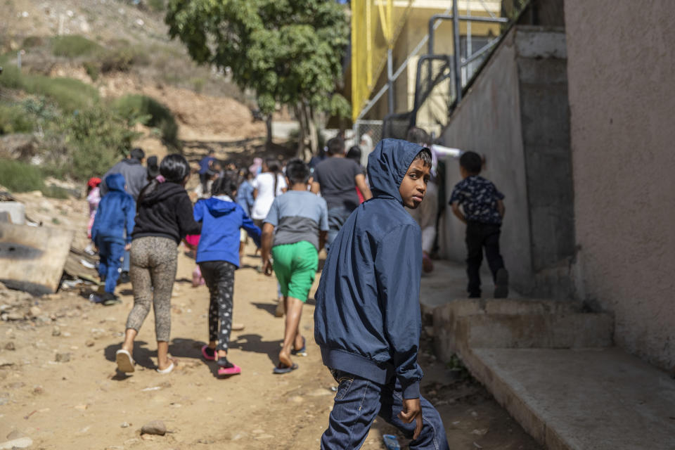 Migrants walk to a religious service at the "Embajadores de Jesus" Christian migrant shelter in Tijuana, Mexico, Tuesday, Sept. 26, 2023. While many places in Mexico provide shelter for migrants from other countries, some shelters in Tijuana have seen an influx of Mexicans fleeing violence, extortion and threats by organized crime. (AP Photo/Karen Castaneda)