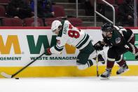 Minnesota Wild left wing Kirill Kaprizov (97) gets tripped by Arizona Coyotes defenseman Niklas Hjalmarsson (4) during the second period of an NHL hockey game Wednesday, April 21, 2021, in Glendale, Ariz. (AP Photo/Ross D. Franklin)