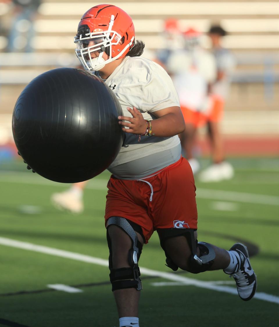 A San Angelo Central High School football player takes a medicine ball over to the sidelines during the first preseason practice at San Angelo Stadium on Monday, Aug. 8, 2022.