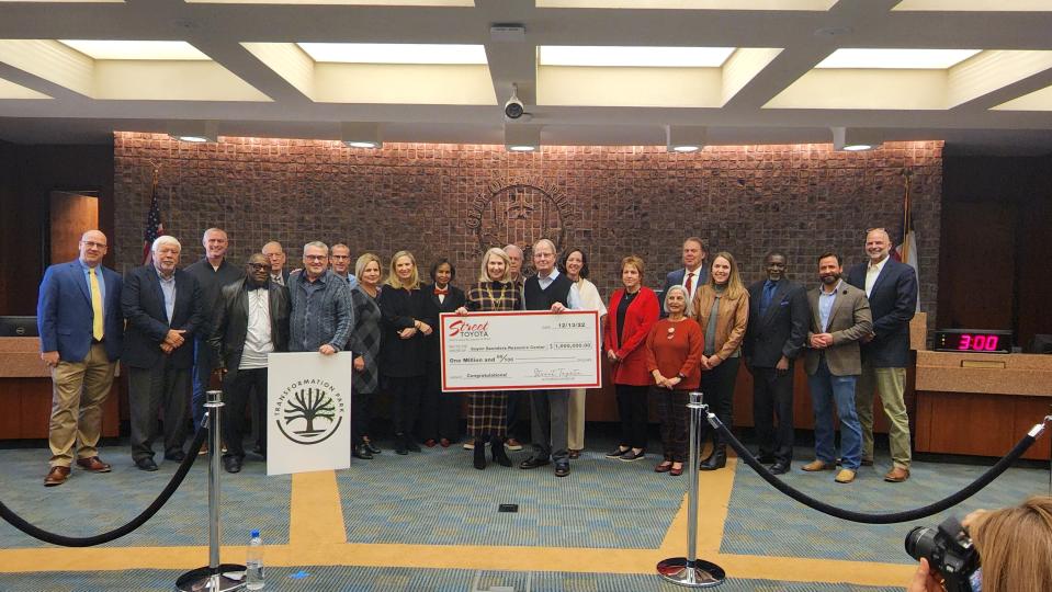 Joe and Laura Street of Street Toyota stand with city and community partners with their donation check of $1 million toward the planned Transformation Park at the Dec. 13 city council meeting in downtown Amarillo.