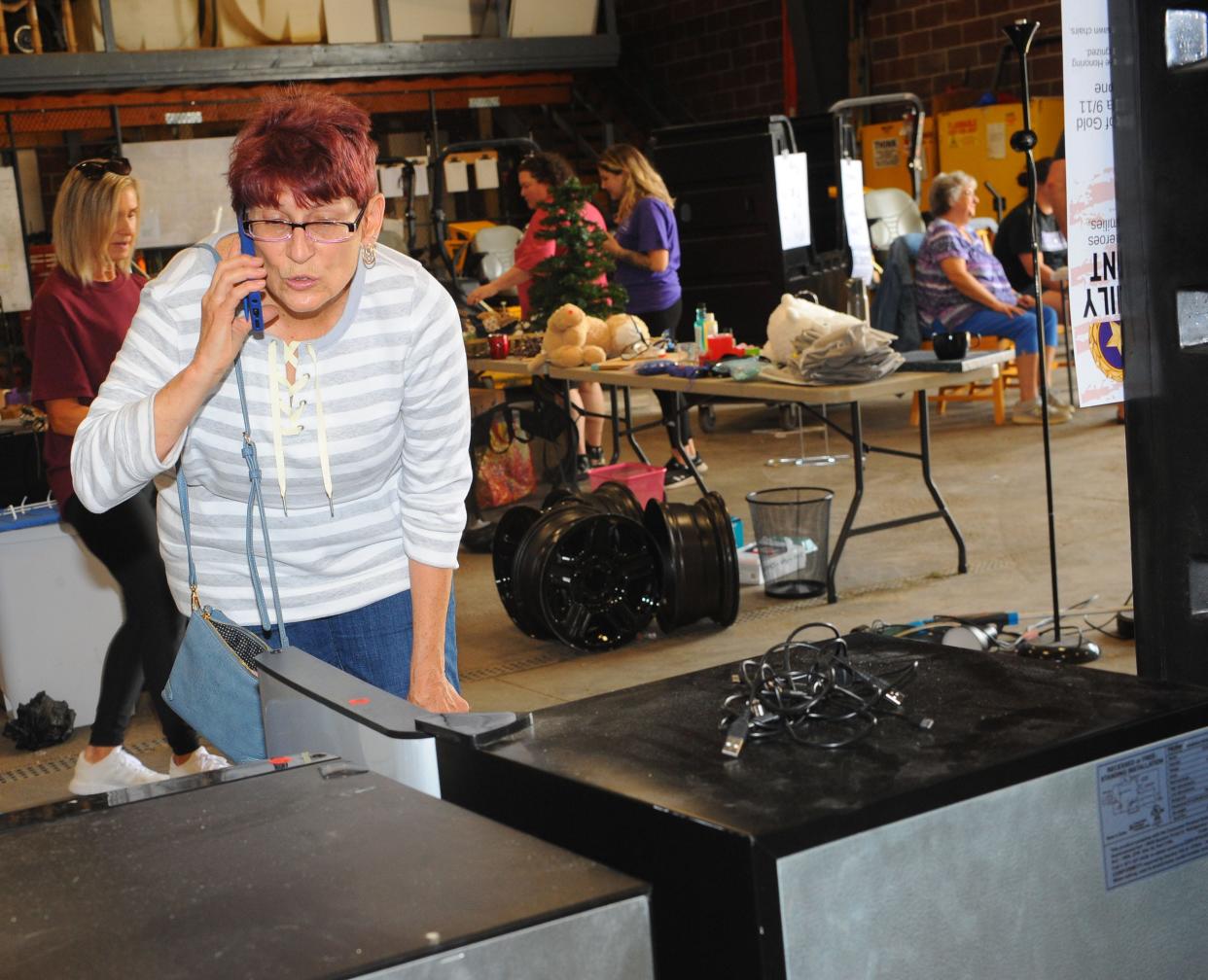Susan Meece calls a friend as she decides whether to purchase a small refrigerator Thursday, May 19, 2022, during the annual "Trash to Treasure" sale at University of Mount Union Physical Plant. A variety of items were available for purchase, and proceeds will benefit community projects in Alliance.