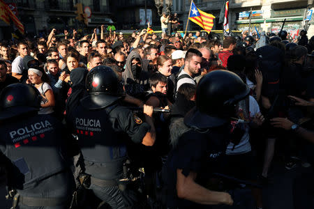 Separatist protesters scuffle with Mossos d'Esquadra police officers as they protest against a demonstration in support of the Spanish police units who took part in the operation to prevent an independence referendum in Catalonia on October 1, 2017, in Barcelona, Spain, September 29, 2018. REUTERS/Jon Nazca