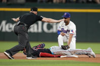 Washington Nationals' Luis Garcia Jr. is safe with a double under the attempted tag by Texas Rangers second baseman Marcus Semien as umpire Ryan Blakney signals safe in the first inning of a baseball game in Arlington, Texas, Thursday, May 2, 2024. (AP Photo/Tony Gutierrez)