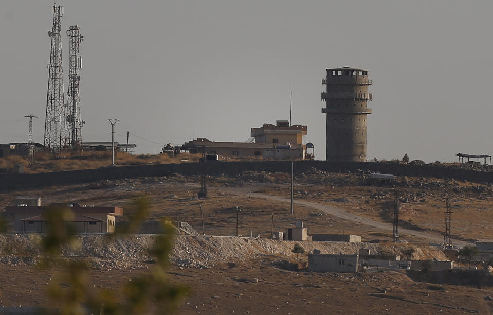 In this photo taken from the Turkish side of the border between Turkey and Syria, in Suruc, southeastern Turkey, a U.S forces outpost is seen on a hilltop outside Ayn Al Arab or Kobani, Syria, Saturday, Oct. 12, 2019. U.S. officials say an American outpost in northeastern Syria has been vacated after coming under fire from Turkish artillery. The officials say a number of U.S. troops left their post on a hill outside the town of Kobani after it came under fire. Turkey says it didn't target the U.S. outpost but was responding to fire from Kurdish groups nearby. (AP Photo/Emrah Gurel)